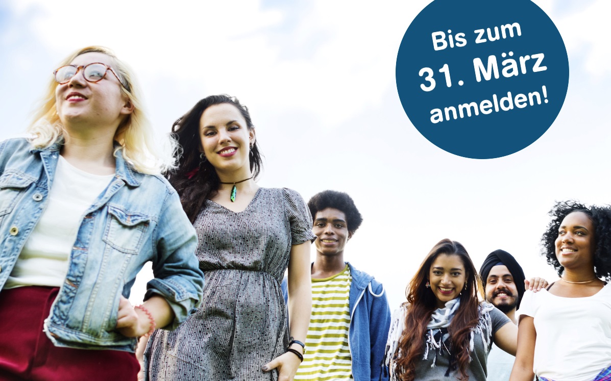 Eine Gruppe junger Menschen verschiedener Herkunft schaut lächelnd nach oben. Im Bild ist ein blaues Banner mit dem Aufruf "Bis zum 31. März anmelden!".