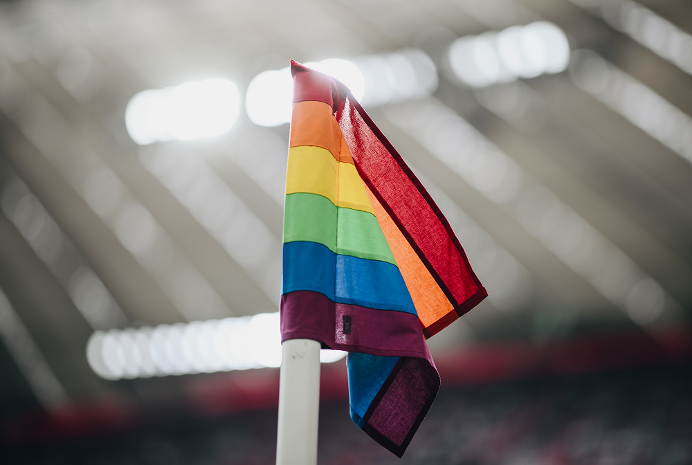 Eine Regenbogeneckfahne weht im Fußballstadion.