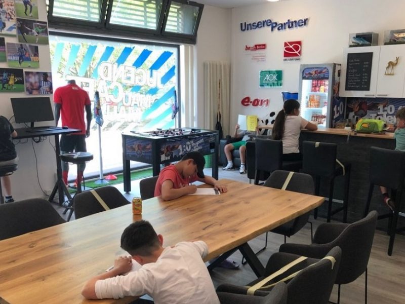 Kinder sitzen im Jugend Café und schreiben und lesen