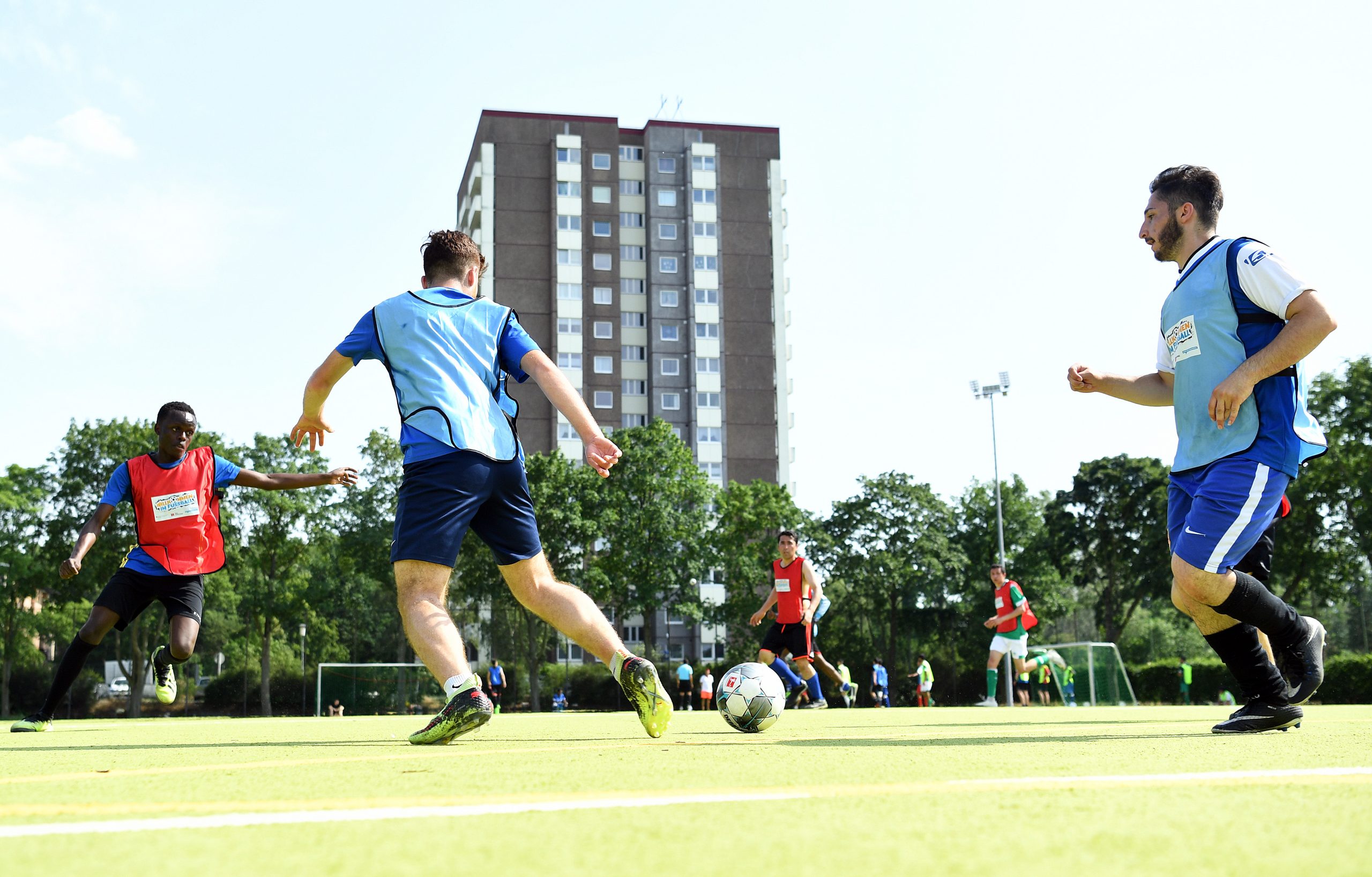 Jungen in blauen und roten Trikots spielen Fußball