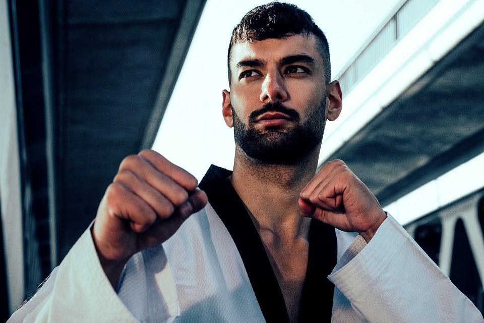 Taekwondo-Kämpfer Tahir Gülec schaut mit geballten Fäusten in die Kamera.