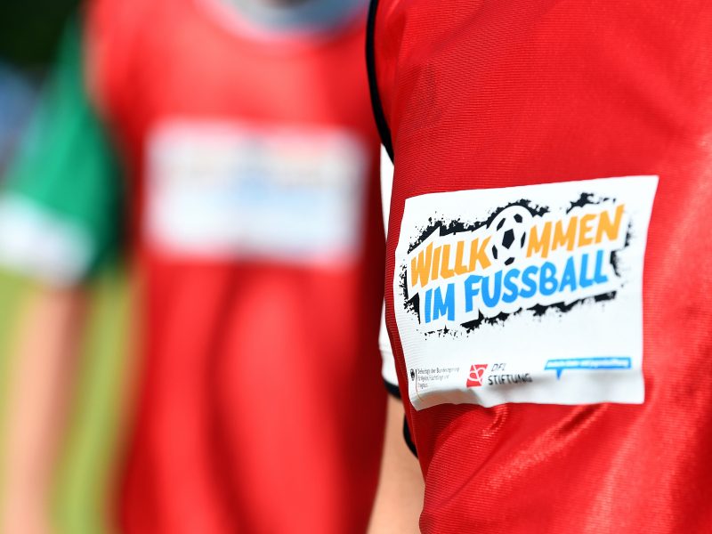 Zwei Jungen in roten Trikots mit dem Logo „Willkommen im Fußball"