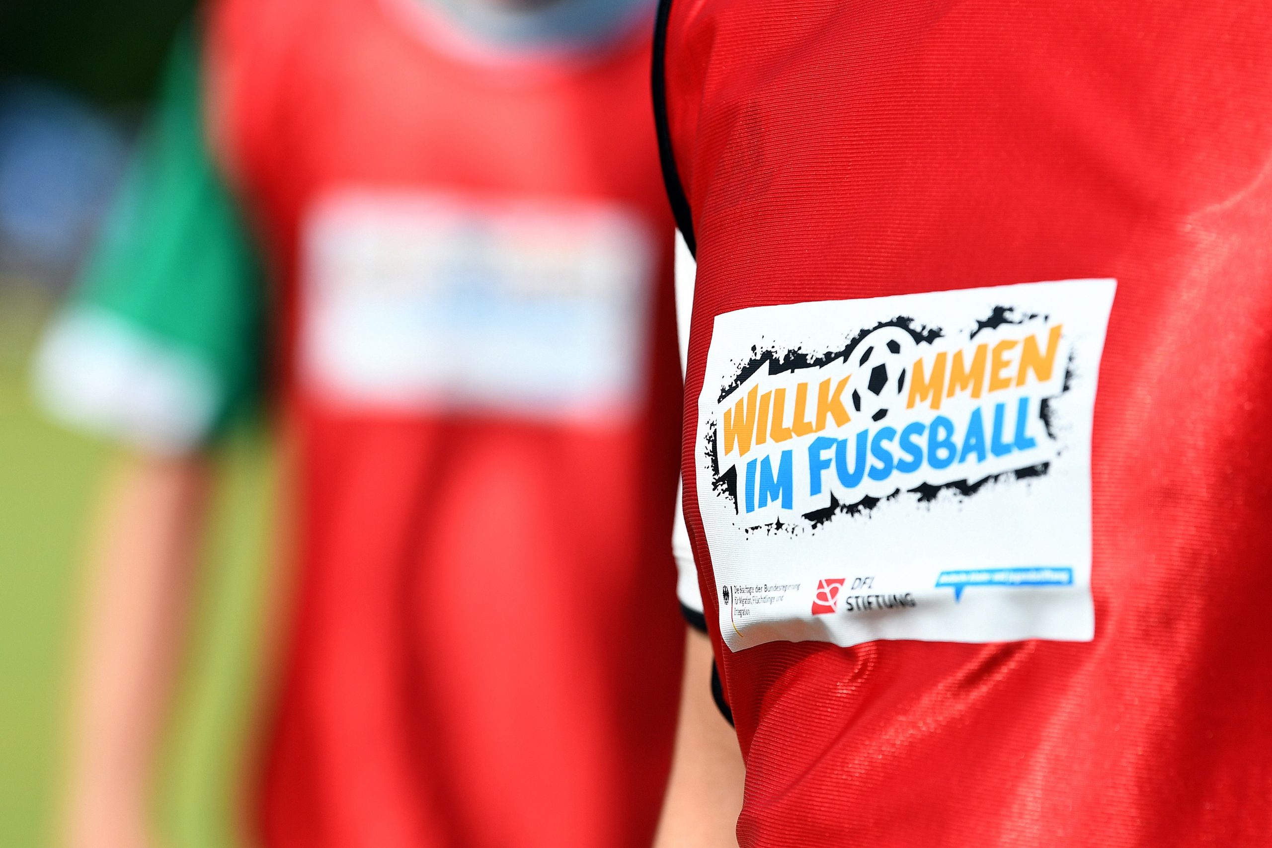 Zwei Jungen in roten Trikots mit dem Logo „Willkommen im Fußball"