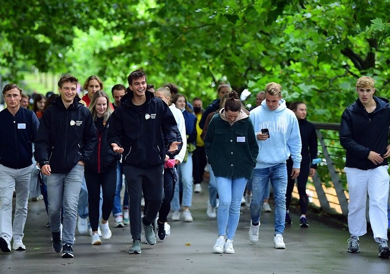 Die Athletinnen und Athleten laufen über die Brücke zum Stadion