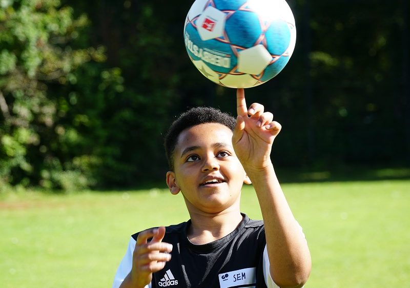 Ein Junge dreht den Ball auf dem Zeigefinger.