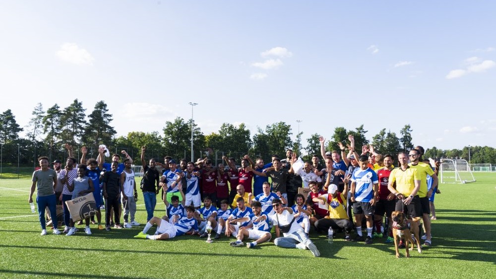 Alle Teilnehmenden des 5. lokalen „Willkommen im Fußball“-Cups stehen auf dem Fußballfeld