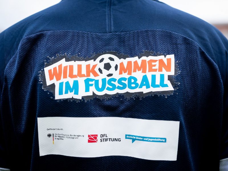 Trikot mit den Logos von Willkommen im Fußball und Partnerorganisationen.