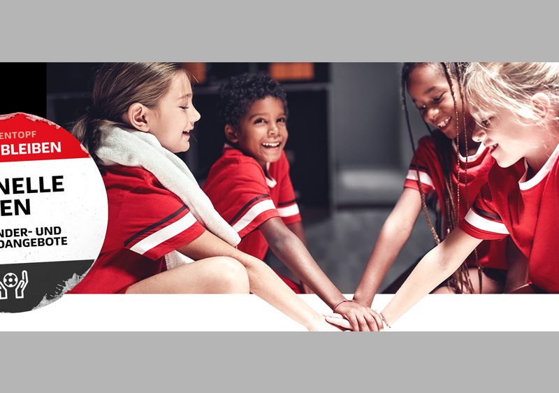 Zu sehen sind vier Kinder in roten T-Shirts, die ihre Hände in der Mitte übereinanderlegen. Außerdem ein großer Aufkleber, auf dem "Schnelle Hilfen für Kinder- und Jugendangebote" steht.