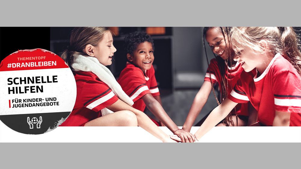 Zu sehen sind vier Kinder in roten T-Shirts, die ihre Hände in der Mitte übereinanderlegen. Außerdem ein großer Aufkleber, auf dem "Schnelle Hilfen für Kinder- und Jugendangebote" steht.