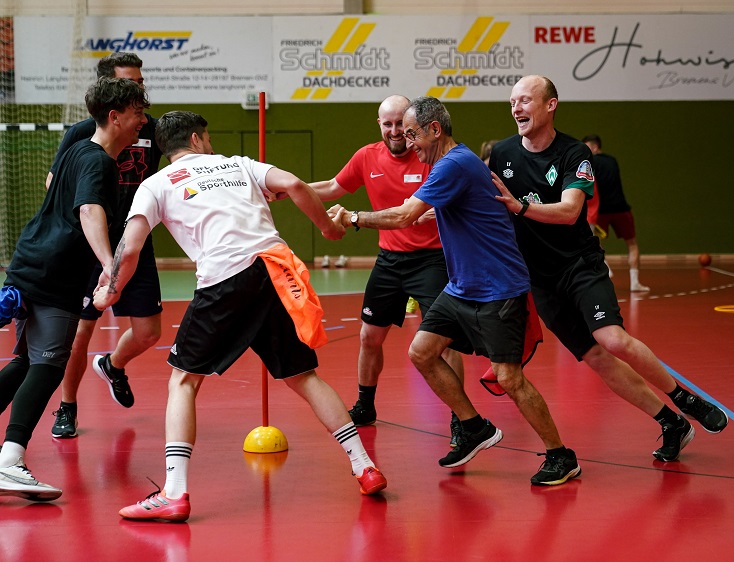 Die Teilnehmenden der Qualifizierungsveranstaltung werden selber sportlich aktiv bei Kooperationsspielen in einer Turnhalle.