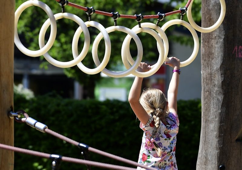 Ein Mädchen hangelt sich an weißen Ring voran