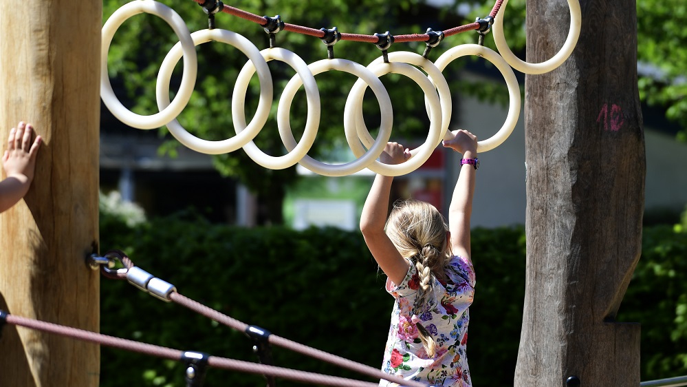 Ein Mädchen hangelt sich an weißen Ring voran