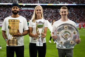 Banner mit der Aufschrift "Nie wieder!" und "Erinnern reicht nicht" im Stadion während einer Fußballveranstaltung, im Hintergrund zahlreiche Zuschauer.