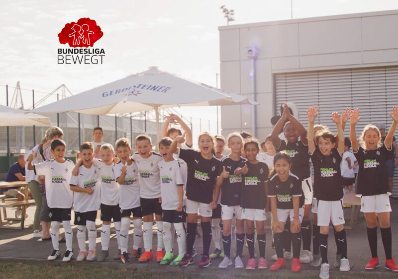 Auf dem Foto sind mehrere Kinder in Sportkleidung nebeneinander zu sehen. Sie jubeln.
