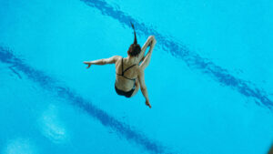 Lena Hentschel ist Wasserspringerin und springt gerade im gestreckten Salto ins Wasser.