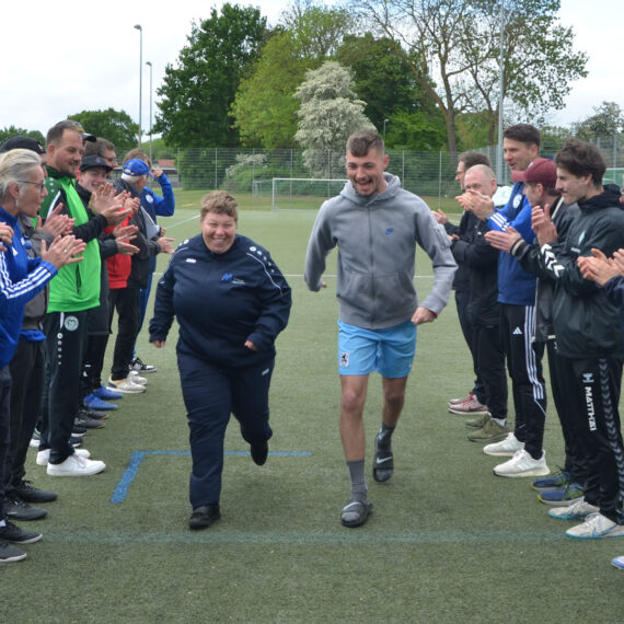 Zwei Menschen laufen lachend durch ein Spalier aus Menschen