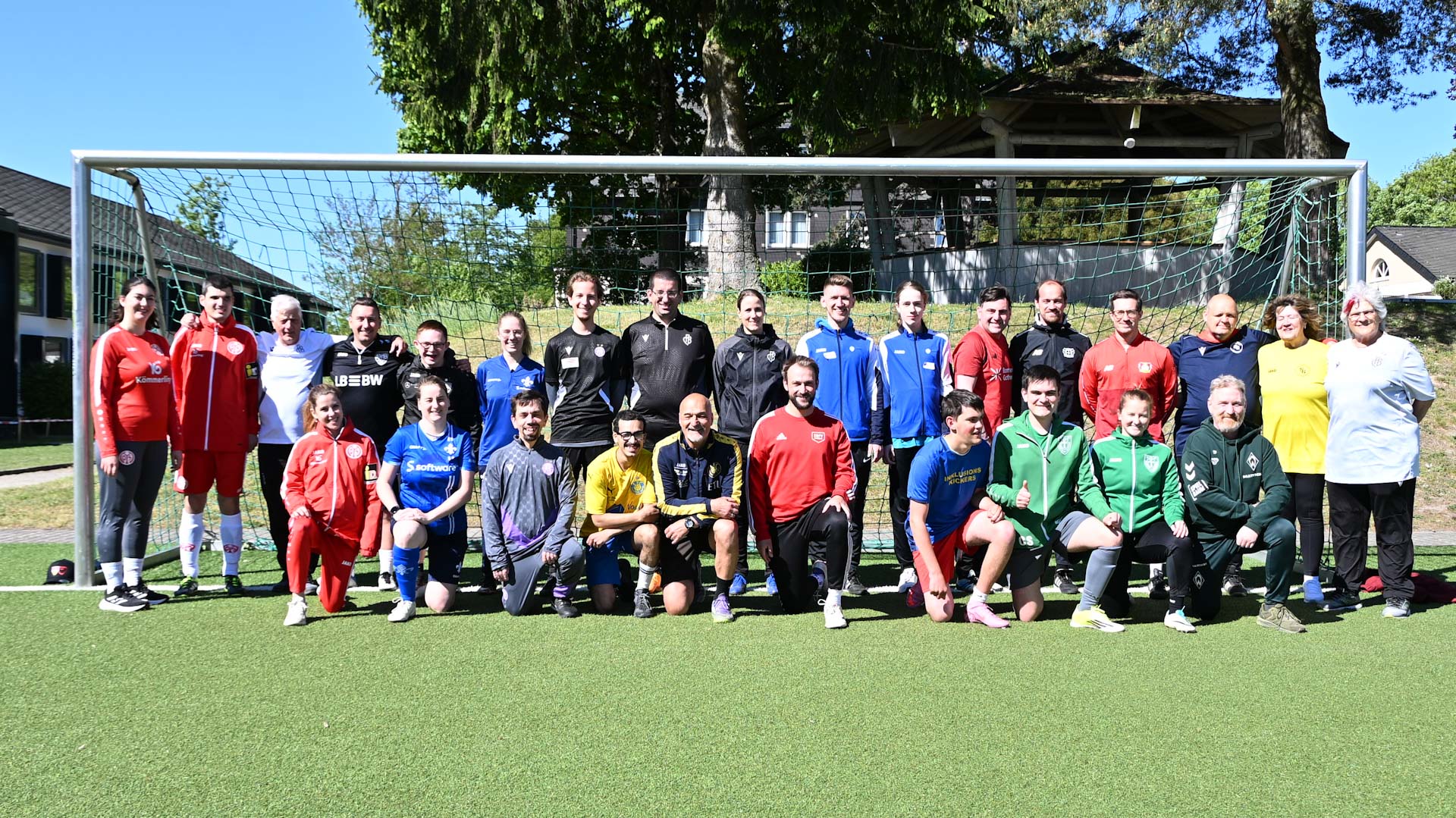 Die Teilnehmenden der Tandem Young Coach Ausbildung stehen für ein Gruppenfoto in einem Tor